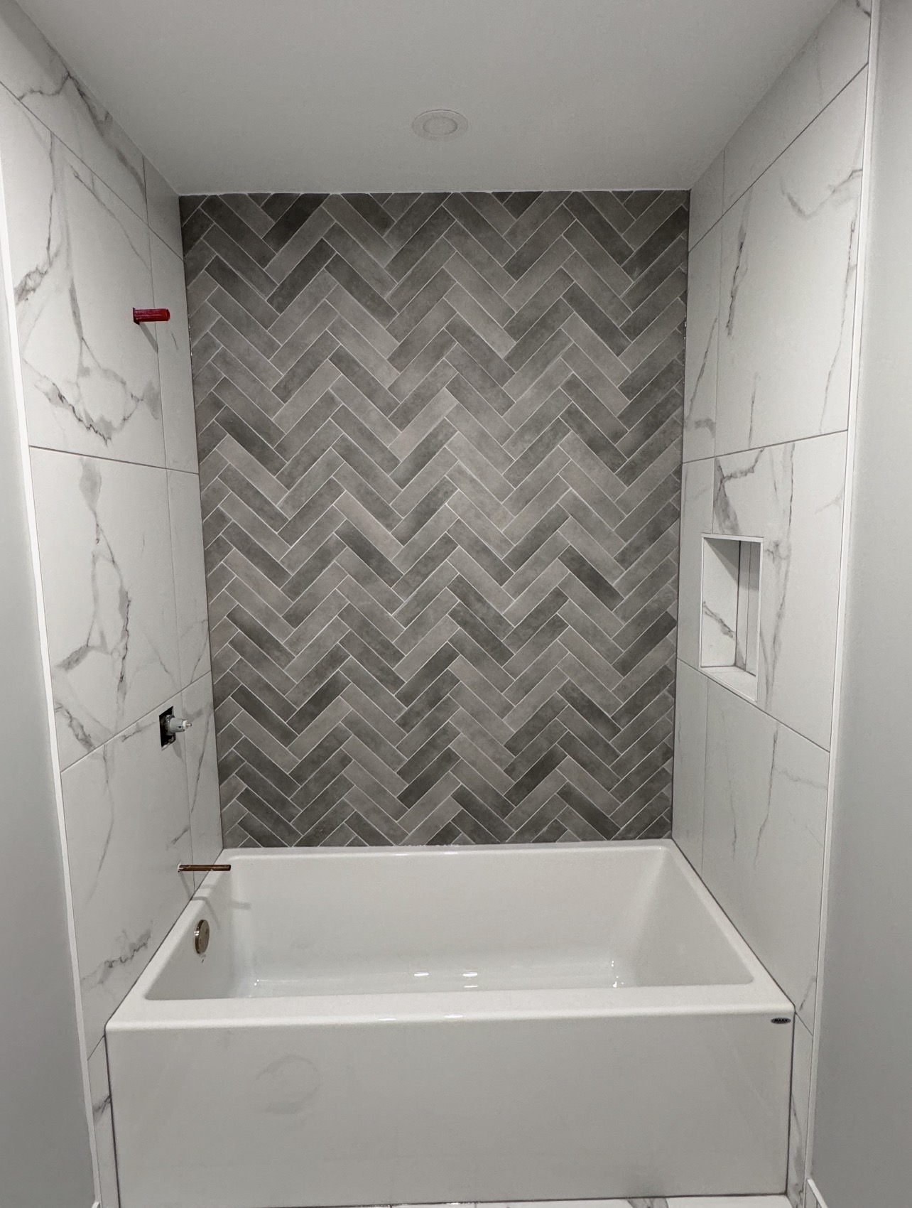 Herringbone tile pattern master bathroom floor installation in Orléans, Ottawa